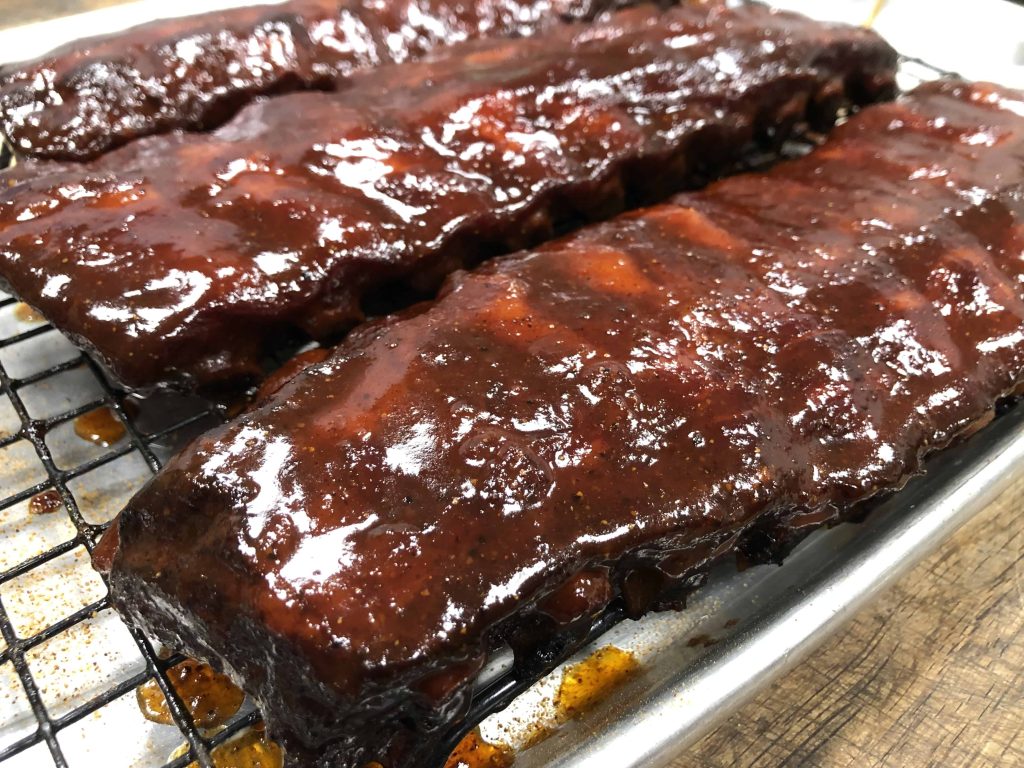 Juicy, slow-smoked BBQ meats piled high, showcasing the rich, caramelized bark and tender texture, embodying the essence of traditional New Orleans barbecue.