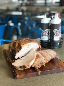 Juicy sliced smoked turkey breast on a wooden board at Central City BBQ restaurant - Barbecue New Orleans