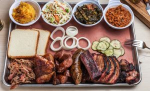 Assorted Central City BBQ plate featuring BBQ New Orleans style ribs, sausage, brisket, and classic sides. How much BBQ should I order.